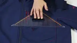 Mit einer Schneiderkreide den „Rahmen“ des später aufzubringenden Flickens um die betroffene Stelle zeichnen.