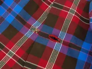 How do I sew a button onto my Vaude shirt?